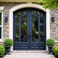 Arched Double Doors With Decorative Wrought Iron and Stone Surround