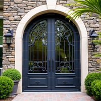 Arched Double Front Door With Decorative Metal Scrollwork and Stone Surround