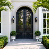 Arched Double Door With Wrought Iron and Sconces Flanked by Urns