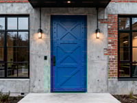 Bright Blue Industrial Door With Metal X Design and Riveted Details