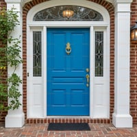 Bright Blue Paneled Front Door With Gold Accents and Sidelights
