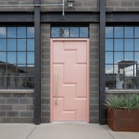 Light Pink Geometric Door With Silver Handle and Concrete Frame