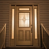 Tan Entry Door With Decorative Window, Sidelights, and Black Hardware